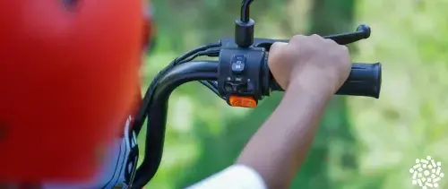Criança de capacete segura o guidão da bicicleta. Entenda os cuidados necessários para usar bicicletas elétricas