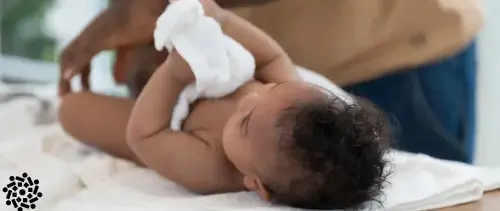 Pai observa sinais de fimose em seu filho bebê, ao trocar a fralda.