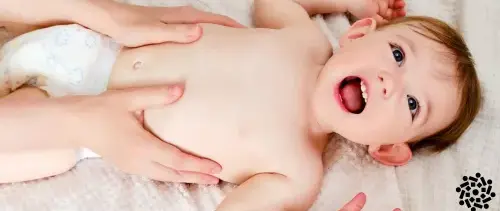 Mãe massageia a barriga de seu bebê: essa é uma das medidas para aliviar os sintomas de gases em crianças