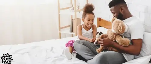 Criança brinca com o pai e com bichos de pelúcia. A brincadeira ajuda a desenvolver habilidades importantes para a vida