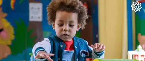 Criança pequena participa do Jogo das Tampinhas: uma brincadeira simples e cheia de aprendizados